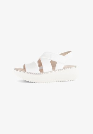 Sandali platform bianchi con suola texturizzata e ampie cinghie incrociate, dotati di una cinghia sul retro per supporto. Materiale sintetico liscio.