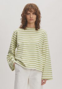 Grün- und weiß gestreiftes Langarmshirt mit Rundhalsausschnitt, weichem Baumwollmaterial, lockerer Passform und leicht gesenkten Schultern.