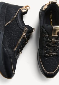 Sneakers neri con accenti dorati, pelle lucida, tessuto texturizzato e cerniere decorative. Presentano una suola spessa e una chiusura con lacci. Taglia 37.