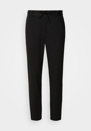 Czarne spodnie wykonane z miękkiej tkaniny, z paskiem ściągającym w talii, o wąskim kroju i zwężanych nogawkach. Bez charakterystycznych wzorów ani zdobień.