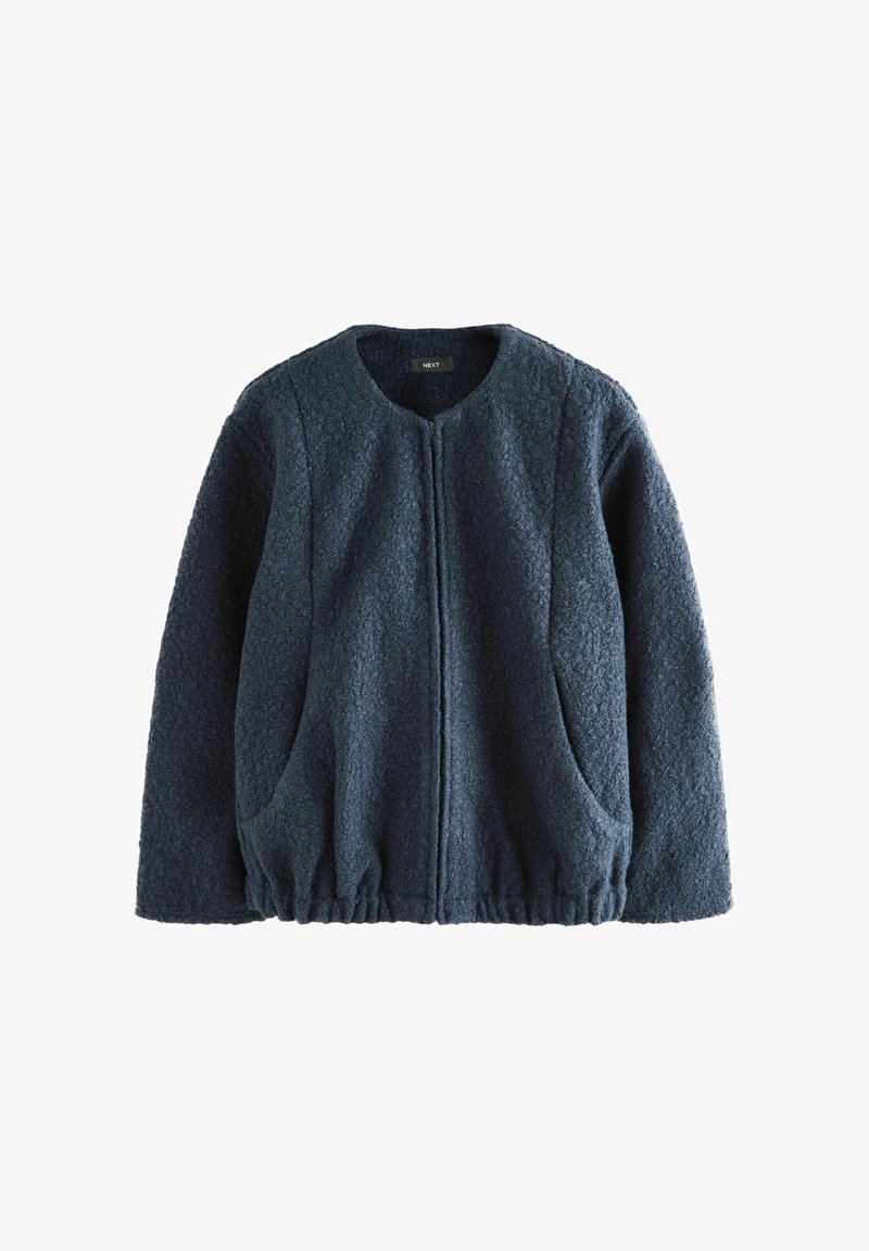 Veste polaire texturée bleu foncé à manches longues, col rond, fermeture éclair devant, deux poches latérales et bas élastiqué.
