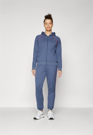 Survêtement de sport marine avec des accents roses. Comprend un sweat à capuche zippé et un pantalon fuselé, fabriqué à partir d'un tissu lisse et extensible.