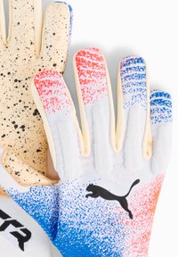 Gants de gardien de but blancs avec des motifs pixelisés rouges et bleus et un logo Puma noir sur le dessus, avec des paumes en beige texturé.