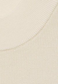 Tessuto lavorato a maglia color crema caratterizzato da un motivo testurizzato, con un ampio scollo a costine e una finitura liscia e morbida. La forma complessiva è arrotondata.