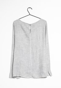 Blusa grigia chiaro a maniche lunghe realizzata in tessuto testurizzato, con scollatura rotonda, spacco posteriore e spacchi laterali all'orlo.