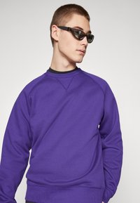 Carhartt WIP CHASE - Sportska majica - tyrian/gold