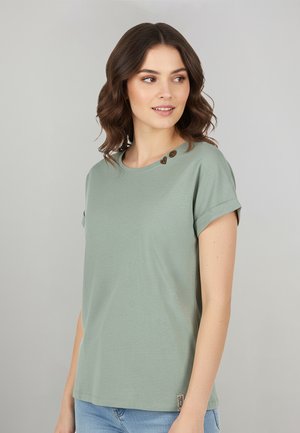 Hellgrünes Kurzarm-T-Shirt aus weichem Stoff, mit aufgerollten Ärmeln und drei dekorativen Knöpfen an der linken Schulter.