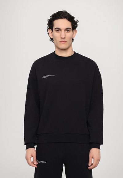 Schwarzer Rundhalsausschnitt Sweatshirt aus Baumwollmischung, mit einem kastigen Schnitt, gerippten Bündchen und einem kleinen weißen Textdetail auf der Vorderseite.