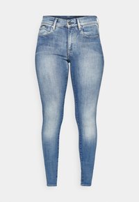 Jeans ajustados de un azul claro, elaborados en denim, que presentan un diseño clásico de cinco bolsillos, sutiles desgastes y un cierre de cremallera con un botón.