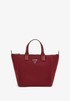 Sac cabas bordeaux en matériau lisse, avec deux anses supérieures, une fermeture éclair et une plaque de logo à l'avant.