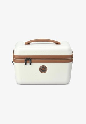 Estuche cosmético blanco de material rígido con un asa de cuero marrón, doble cremallera y emblema circular. Superficie texturizada y forma rectangular compacta.