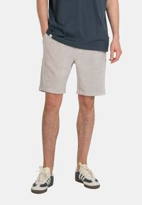 Light gray corduroy shorts with a soft texture, straight cut, side pockets, and a waistband. Paired with dark blue sneakers.