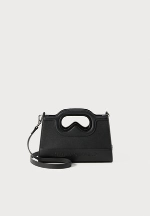 Black leather handbag with a distinctive cut-out handle, structured shape, and embossed brand logo on the front. Adjustable strap included.