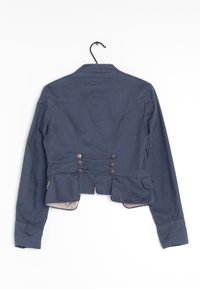 Mörkblå skräddarsydd jacka med långa ärmar, med en peplumslutning, dekorativa knappar och en mjuk textur.