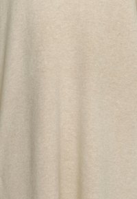 Svetlocihlová tkanina s měkkým, strukturovaným povrchem, která má jemný, jednotný vzhled bez vzorů či výrazných akcentů.