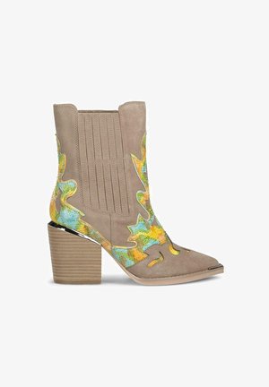 Beige Wildleder-Stiefelette mit mehrfarbigen Blattmustern, spitzer Zehenform und einem gerippten Blockabsatz. Auffällige Ausschnitte an der Seite.