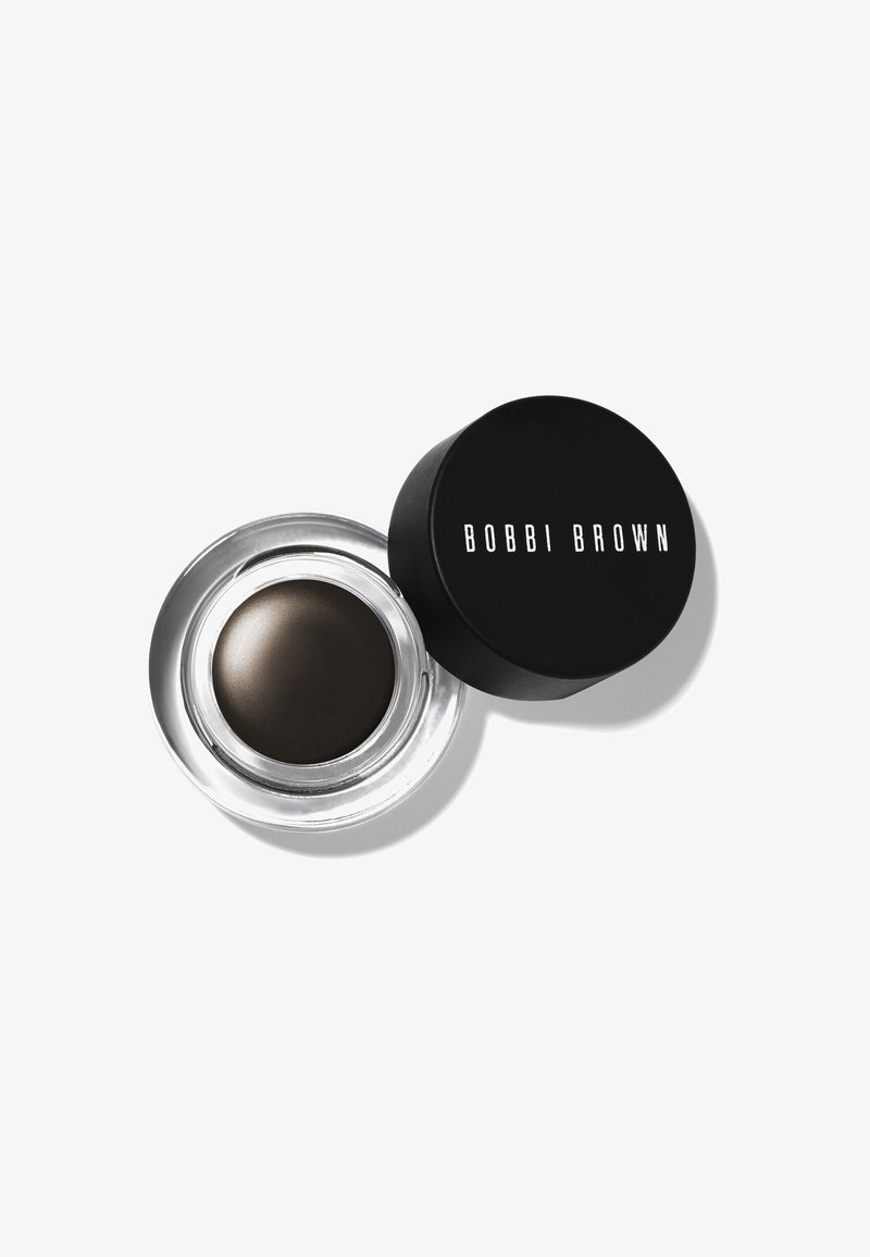Vasetto di vetro aperto con eyeliner in gel marrone scuro con coperchio nero etichettato Bobbi Brown su sfondo bianco.