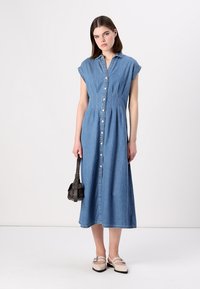 Abito midi in denim con maniche a cappuccio corte, bottoni frontali e una vestibilità rilassata. Presenta un colore azzurro chiaro e dettagli di cuciture a vista sottili.