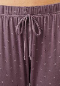Violetit narukankaiset housut, jotka on valmistettu pehmeästä kankaasta ja joissa on hienovarainen vaakasuorien viivojen ja pienten pisteiden kuvio tuomaan rakennetta ja yksityiskohtia.