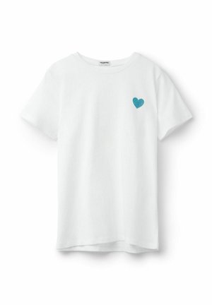 Camiseta blanca de manga corta con cuello redondo y un pequeño corazón bordado en color teal en el pecho izquierdo, mostrada sobre un fondo blanco liso.