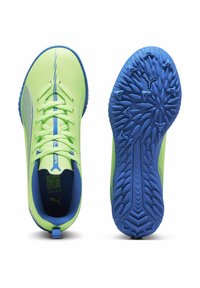 Las zapatillas deportivas de color verde neón cuentan con una parte superior suave, acentos azules, cordones planos y una suela azul texturizada con un diseño de agarre multidireccional.
