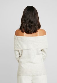 Schulterfreies, hellgraues Sweatshirt mit geripptem Ausschnitt und Bündchen. Weiche Textur; lockere Passform mit einer entspannten Silhouette.