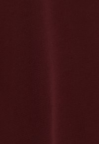 Tessuto color marrone con una texture morbida e opaca, che mostra una superficie liscia e un colore uniforme senza motivi o cuciture visibili.