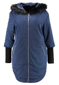 Granatowa puchowa kurtka z odpinanym kapturem z czarnego sztucznego futra, srebrnymi dodatkami, dwoma kieszeniami na suwak i czarnymi dzianinowymi mankietami.