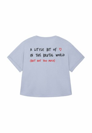 T-shirt surdimensionné bleu clair à manches courtes. Le texte au dos comprend : "Un peu de ❤️ dans ce monde brutal (mais pas trop)."
