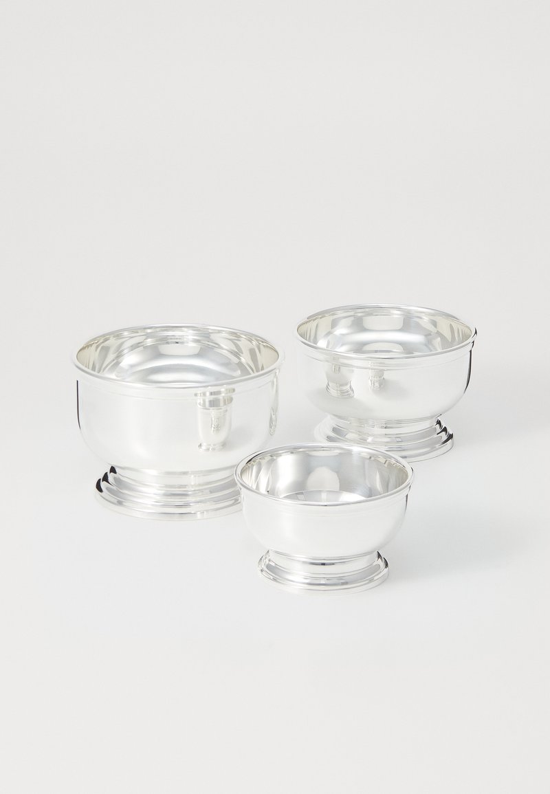 Súprava troch leštených strieborných misiek. Každá má zaoblený tvar, hladký povrch a okrúhlu základňu. Rôzne veľkosti vytvárajú vizuálny záujem.