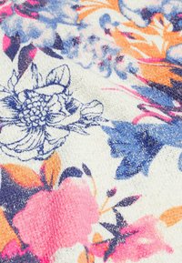Blumiger Stoff mit einer strukturierten Oberfläche zeigt rosa, blaue und orangefarbene Blumen auf einem cremefarbenen Hintergrund und präsentiert aufwendige Muster und Details.