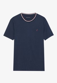 Camiseta de color azul marino con cuello redondo, que presenta un ribete blanco y rojo, y un pequeño logo de pájaro bordado en rojo en el lado izquierdo del pecho.