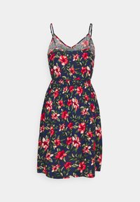 Robe florale avec un fond navy, ornée de fleurs rouges et vertes, à bretelles spaghetti, cintrée à la taille et se terminant par une jupe évasée.