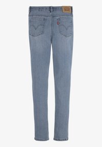 Light blue denim jeans with a straight cut, featuring two back pockets with contrasting stitching and a brown leather patch at the waistband.