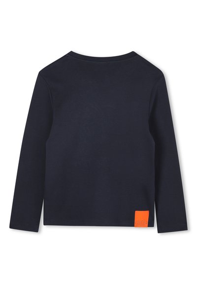 Chemise à manches longues bleu marine, en coton doux, col rond, étiquette orange en bas à gauche, design simple sans motifs.