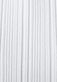 Witte textuurstof met verticale ribbelpatronen, zacht en rekbaar materiaal met een subtiele glans. Geen zichtbare patronen of versieringen.