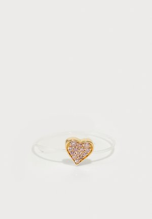 Bague en forme de cœur en or ornée de rhinestones roses, montée sur une fine bande transparente. Surface lisse avec des accents brillants.