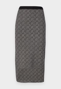 Jupe crayon noir et blanc à motif avec un tissu texturé, dotée d'une taille côtelée et d'un design géométrique tout au long.