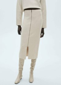 Beige Strickrock in Knielänge mit geripptem Bund und vorderem Reißverschluss, versehen mit einem Seitenschlitz für zusätzlichen Detail.