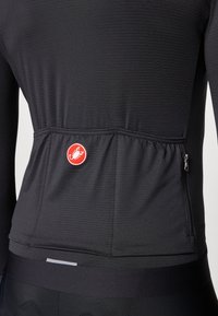 Schwarzes langärmeliges Radtrikot aus strukturiertem Stoff, mit rotem Logo und einer praktischen Reißverschlusstasche auf der Rückseite. Betont durch ein schlankes Design.
