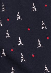 Granatowa tkanina z białymi wyszywanymi drzewami i małymi czerwonymi kropkami, przypominającymi ozdoby, rozmieszczonymi na materiale w regularnym wzorze.