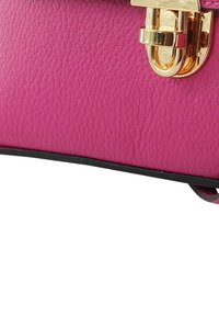 Pink strukturierte Lederhandtasche mit Verschluss in Goldoptik. Verfügt über einen schwarzen Rand entlang der Unterseite. Kompaktes, strukturiertes Design.