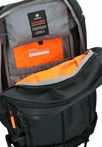 Zaino nero con rivestimento grigio, dotato di un compartimento per il protettore per la schiena arancione. Chiusura con cerniera e materiale resistente. Etichetta interna visibile.