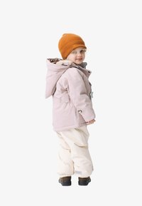 Gevoerde roze jas met grijze voering, voorzien van een sterdetail en capuchon, gecombineerd met een witte sneeuwbroek en een oranje geribde muts.