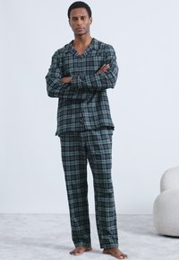 Set di pigiami a quadri verdi e neri con camicia con bottoni e pantaloni con coulisse, realizzato in un tessuto morbido, con maniche lunghe e vestibilità comoda.