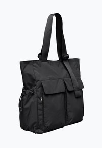 Svart tote-väska gjord av hållbart tyg, med två framfickor, en sidficka och kraftiga, justerbara remmar. Slät textur och funktionell design.