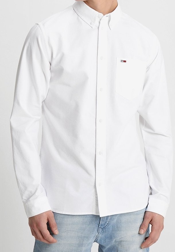 Wit overhemd met lange mouwen en een klassieke kraag, voorzien van een borstzak en een klein logo-accent. Gladde katoenen stof, reguliere pasvorm.