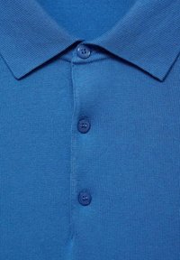 Cămașă polo albastră cu o textură tricotată, guler clasic și trei butoane în față. Butoanele sunt de culoare albastru închis, potrivindu-se cu țesătura.