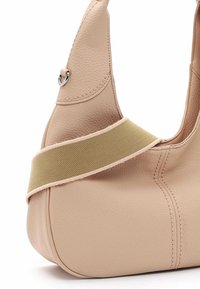 Persiku krāsas ādas rokassoma ar izliekta formu, aprīkota ar plašu oliņu zaļas krāsas siksnu un smalku šuvju detaļām.