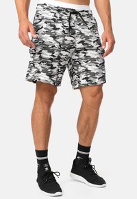 Shorts camo gris et blanc avec une taille élastique, un cordon de serrage, des poches latérales et une coupe décontractée, fabriqués en tissu léger.